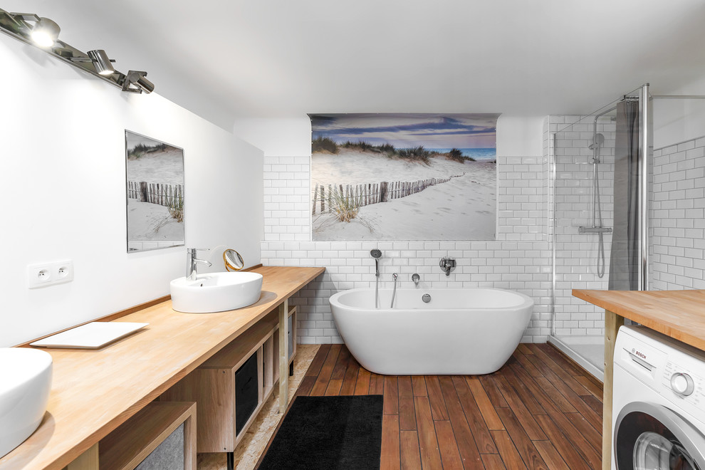 Inspiration for a scandinavian master bathroom in Nice with open cabinets, a freestanding tub, white tile, subway tile, white walls, medium hardwood floors, a hinged shower door, a corner shower, a vessel sink, wood benchtops, brown floor and beige benchtops.