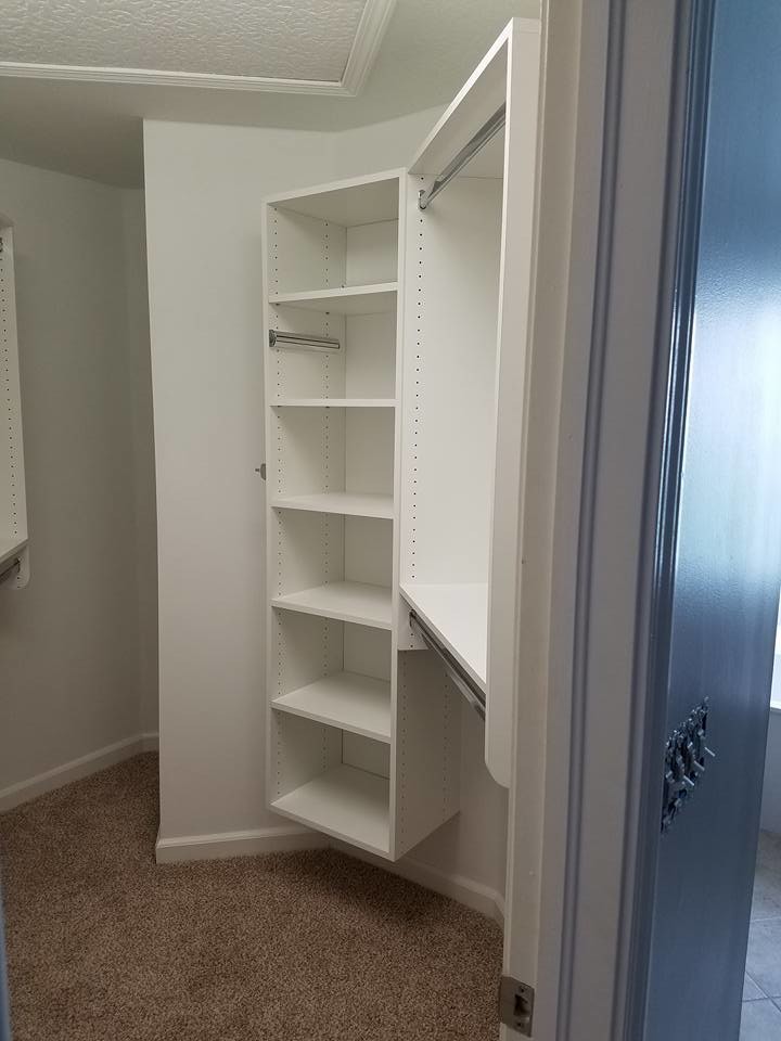 Photo of a mid-sized traditional gender-neutral walk-in wardrobe in Jacksonville with open cabinets, white cabinets, carpet and beige floor.