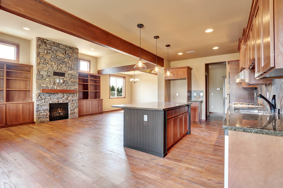 Mid-sized mountain style galley dark wood floor open concept kitchen photo in Seattle with an undermount sink, beaded inset cabinets, black cabinets, granite countertops, multicolored backsplash, stone tile backsplash, stainless steel appliances and an island