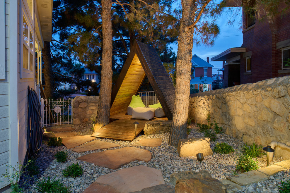 Inspiration for a small traditional backyard xeriscape in Other with a garden path and river rock.