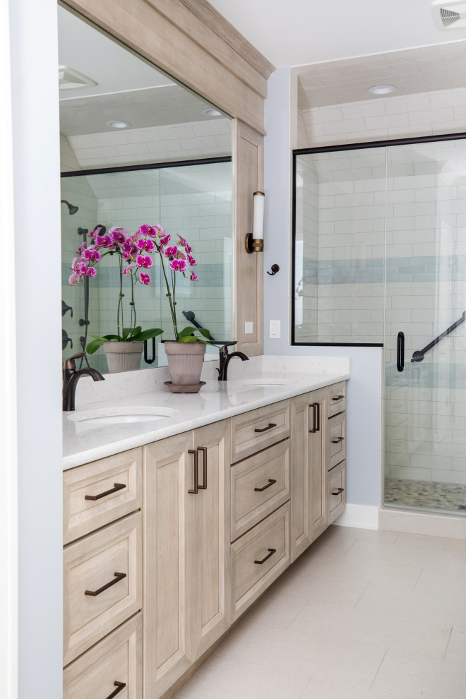 This is an example of a mid-sized beach style 3/4 bathroom in Milwaukee with flat-panel cabinets, light wood cabinets, an alcove shower, white tile, porcelain tile, blue walls, porcelain floors, an undermount sink, engineered quartz benchtops, beige floor, a hinged shower door, white benchtops, an enclosed toilet, a double vanity and a built-in vanity.
