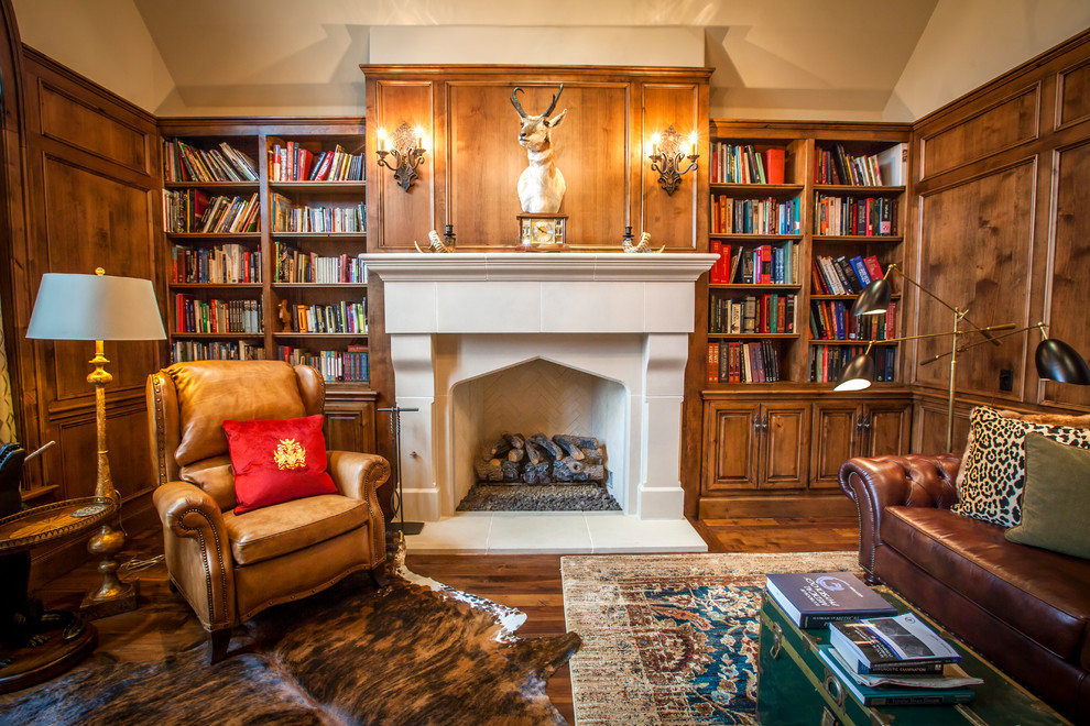 Large traditional study room in Oklahoma City with beige walls, dark hardwood floors, a standard fireplace, a plaster fireplace surround and a freestanding desk.