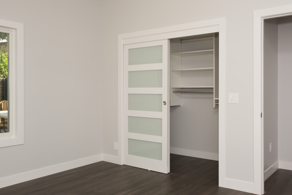 Small contemporary gender-neutral storage and wardrobe in Orange County with dark hardwood floors and brown floor.