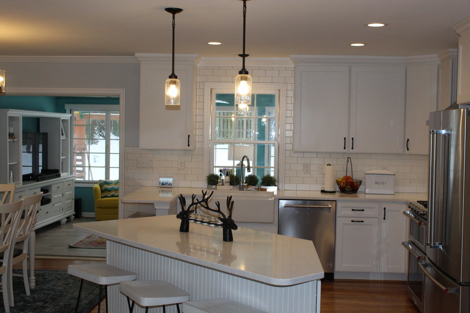 Inspiration for a mid-sized transitional u-shaped eat-in kitchen in DC Metro with a farmhouse sink, white cabinets, granite benchtops, white splashback, ceramic splashback, stainless steel appliances, medium hardwood floors, with island and white benchtop.