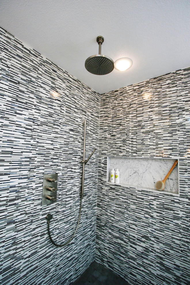 This is an example of a large modern master bathroom in San Francisco with a vessel sink, flat-panel cabinets, grey cabinets, marble benchtops, a freestanding tub, a curbless shower, a wall-mount toilet, gray tile, glass sheet wall, white walls and limestone floors.