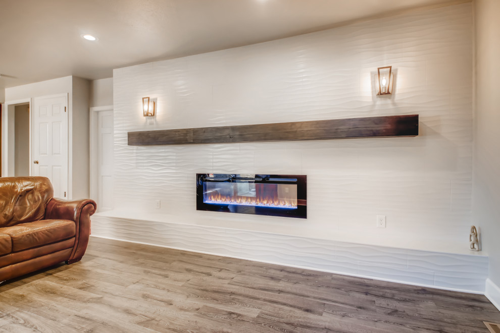 Mittelgroßes, Abgetrenntes Wohnzimmer mit weißer Wandfarbe, Vinylboden, gefliester Kaminumrandung, TV-Wand, braunem Boden, Tapetendecke und Tapetenwänden in Denver