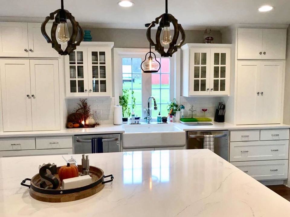 Inspiration for a transitional l-shaped kitchen remodel in Philadelphia with a farmhouse sink, shaker cabinets, white cabinets, marble countertops, white backsplash, subway tile backsplash, stainless steel appliances and an island