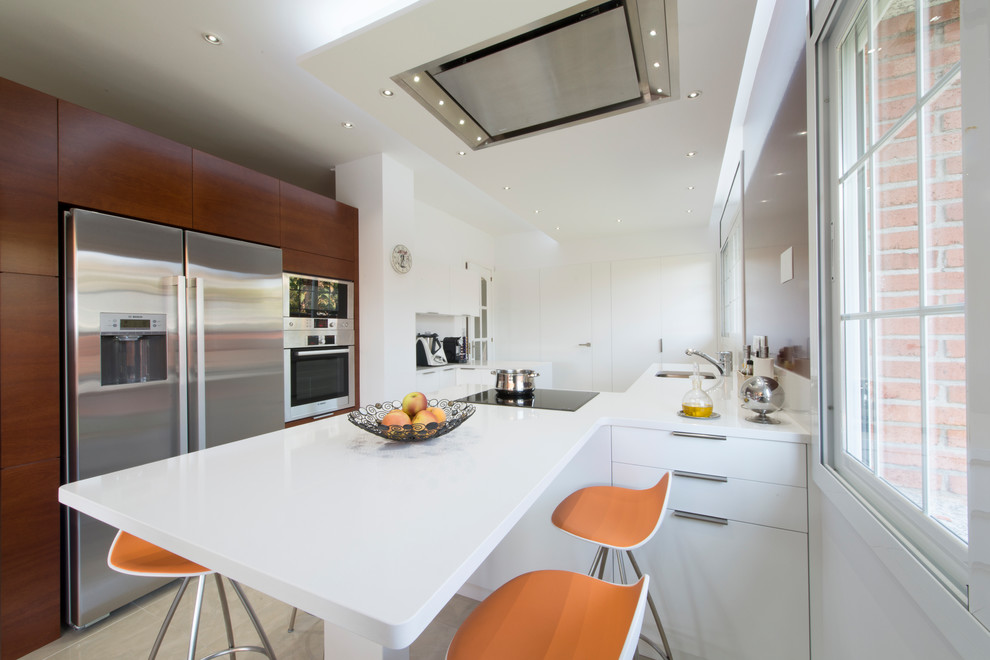 This is an example of a large modern single-wall eat-in kitchen in Other with flat-panel cabinets, white cabinets and a peninsula.