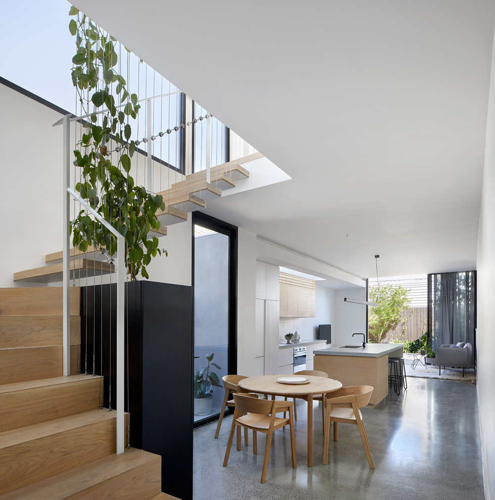 This is an example of a mid-sized contemporary kitchen/dining combo in Melbourne with white walls, concrete floors and grey floor.