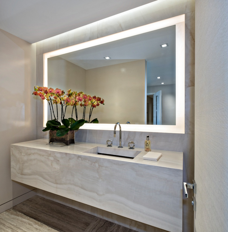 Photo of a mid-sized modern powder room in Miami with flat-panel cabinets, beige cabinets, beige tile, beige walls, an undermount sink, grey floor and beige benchtops.