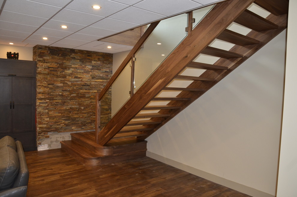 Photo of a mid-sized modern wood straight staircase in Other with open risers and glass railing.