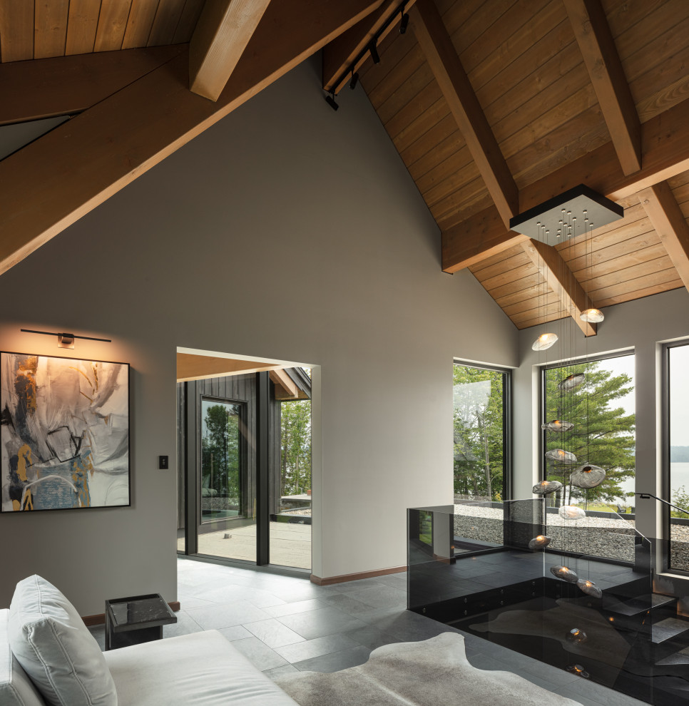 Стильный дизайн: коридор в современном стиле с серыми стенами, полом из сланца и деревянным потолком - последний тренд