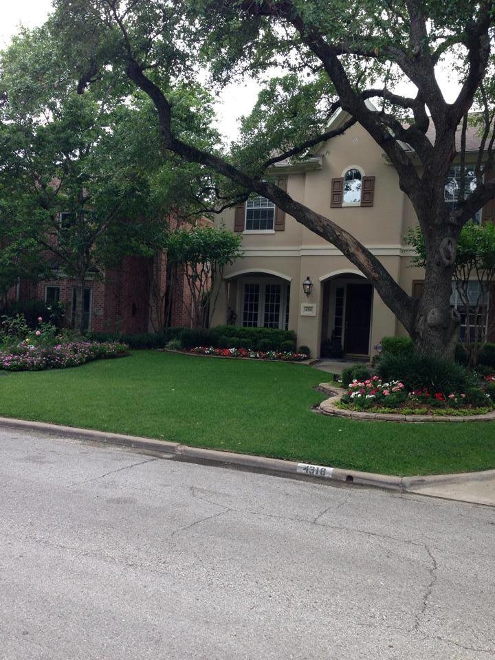 This is an example of a large front yard shaded garden in Houston with a container garden and concrete pavers.