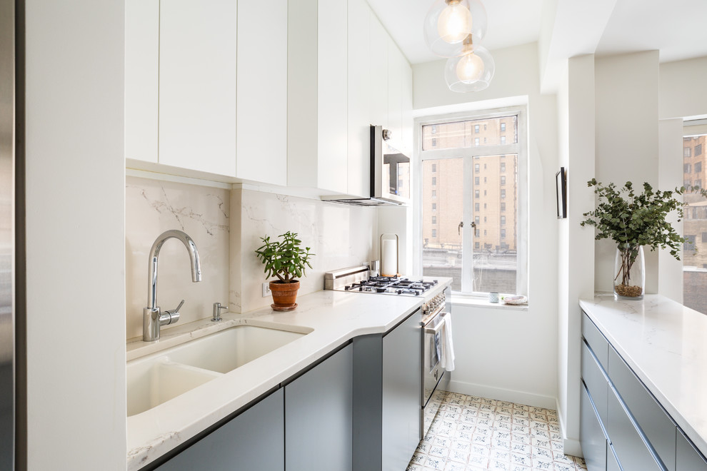 Design ideas for a small transitional galley kitchen in New York with a double-bowl sink, flat-panel cabinets, grey cabinets, quartz benchtops, white splashback, stainless steel appliances, terra-cotta floors, white benchtop, a peninsula and multi-coloured floor.