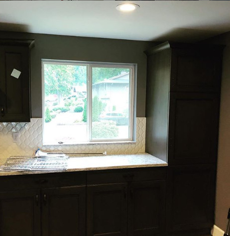 Inspiration for a mid-sized transitional light wood floor and brown floor kitchen remodel in Seattle with an undermount sink, flat-panel cabinets, brown cabinets, quartz countertops, white backsplash, mosaic tile backsplash, stainless steel appliances and white countertops