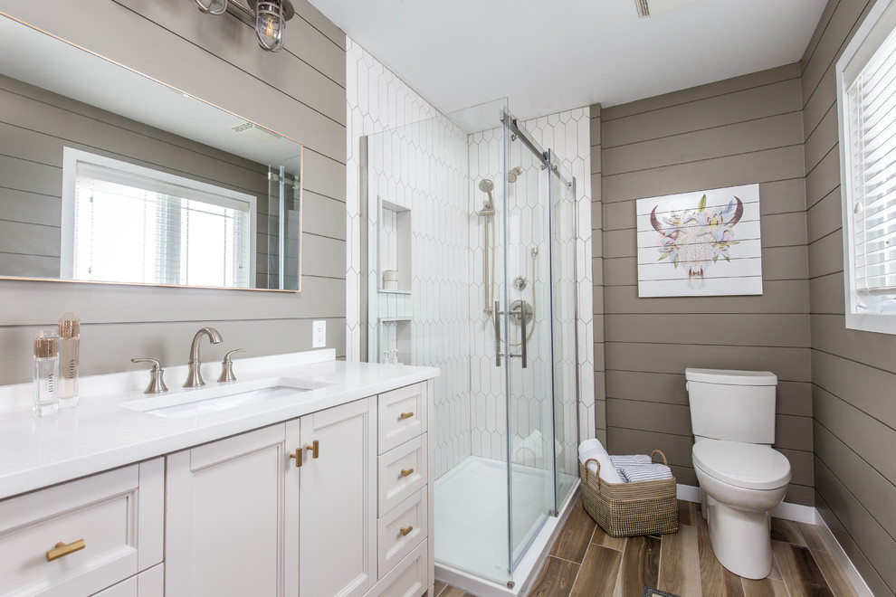 This is an example of a transitional 3/4 bathroom in Toronto with a corner shower, white tile, porcelain tile, grey walls, an undermount sink, quartzite benchtops, brown floor, a sliding shower screen, recessed-panel cabinets and beige cabinets.