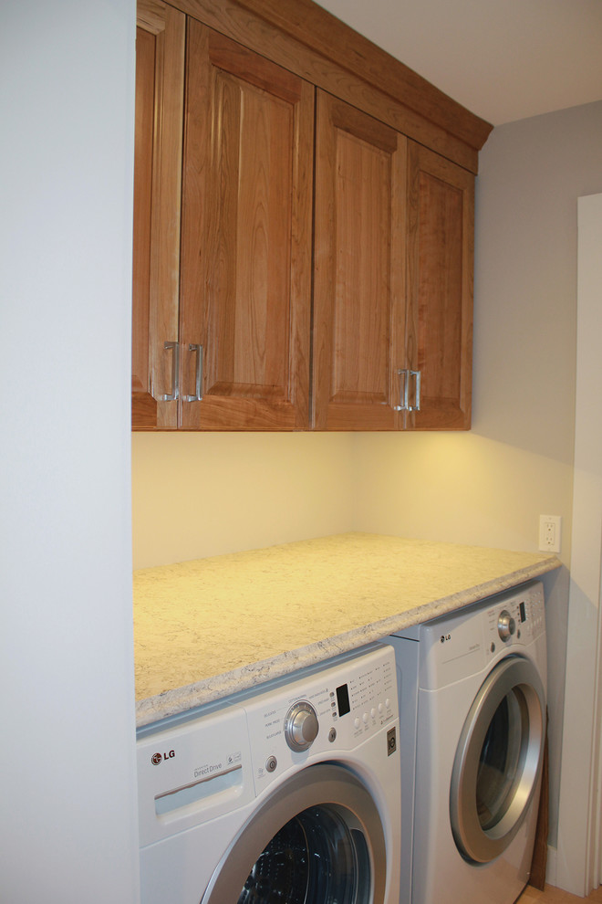 Large transitional u-shaped light wood floor and beige floor open concept kitchen photo in Boston with an undermount sink, raised-panel cabinets, medium tone wood cabinets, quartz countertops, multicolored backsplash, glass tile backsplash, stainless steel appliances, an island and beige countertops