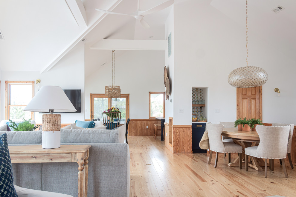Großes, Offenes Maritimes Wohnzimmer mit Hausbar, weißer Wandfarbe, braunem Holzboden, TV-Wand und gewölbter Decke in Sonstige