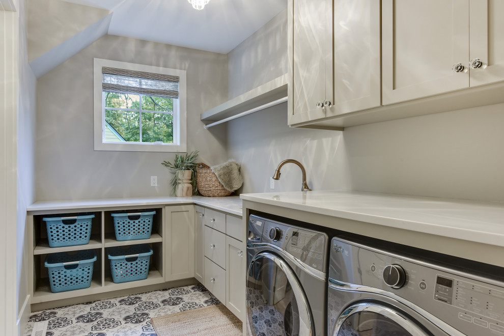 Design ideas for a mid-sized country l-shaped dedicated laundry room in Minneapolis with a drop-in sink, shaker cabinets, grey cabinets, quartz benchtops, beige walls, porcelain floors, a side-by-side washer and dryer, blue floor and beige benchtop.