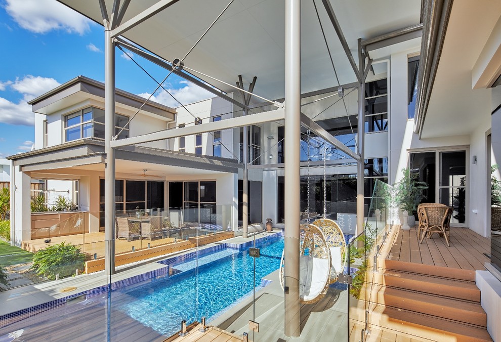 Design ideas for a large beach style backyard custom-shaped lap pool in Sydney with concrete pavers and a hot tub.