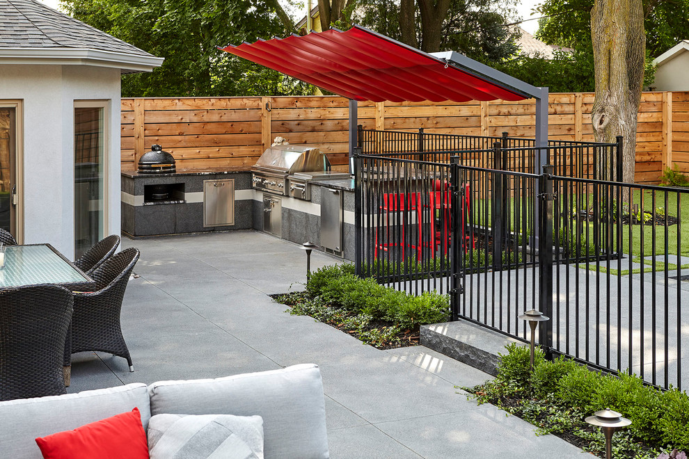 Modern backyard patio in Toronto with an outdoor kitchen, concrete pavers and a gazebo/cabana.