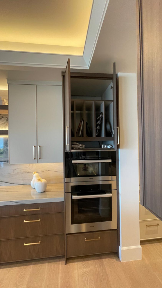 Photo of a large classic l-shaped kitchen pantry in Orange County with a submerged sink, shaker cabinets, white cabinets, granite worktops, multi-coloured splashback, granite splashback, stainless steel appliances, light hardwood flooring, an island, brown floors, multicoloured worktops and all types of ceiling.