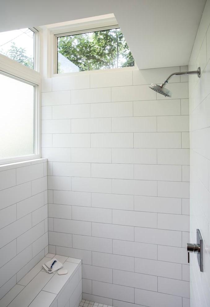 Photo of a midcentury master bathroom in Austin with furniture-like cabinets, medium wood cabinets, an open shower, a two-piece toilet, white tile, ceramic tile, grey walls, concrete floors, an undermount sink and marble benchtops.