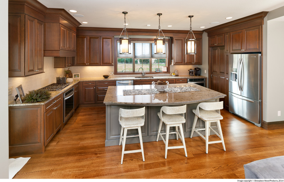 Transitional u-shaped medium tone wood floor and brown floor open concept kitchen photo with a double-bowl sink, raised-panel cabinets, dark wood cabinets, granite countertops, white backsplash, stainless steel appliances, an island and mosaic tile backsplash