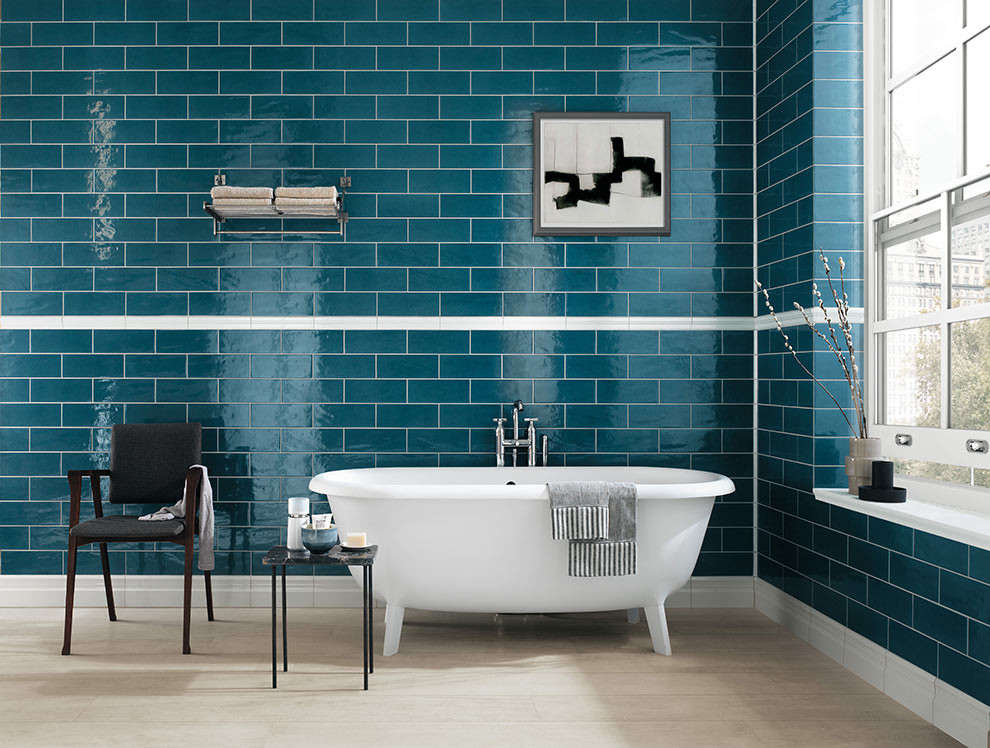 Inspiration for a large contemporary bathroom in Seattle with a freestanding tub, blue tile, subway tile and light hardwood floors.