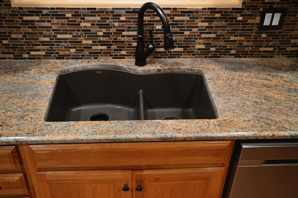 Inspiration for a mid-sized transitional scratch-resistant double bowl and rectangular kitchen remodel in Austin with 1 faucet hole, a double-bowl sink, raised-panel cabinets, light wood cabinets, granite countertops, multicolored backsplash, glass tile backsplash, stainless steel appliances and no island
