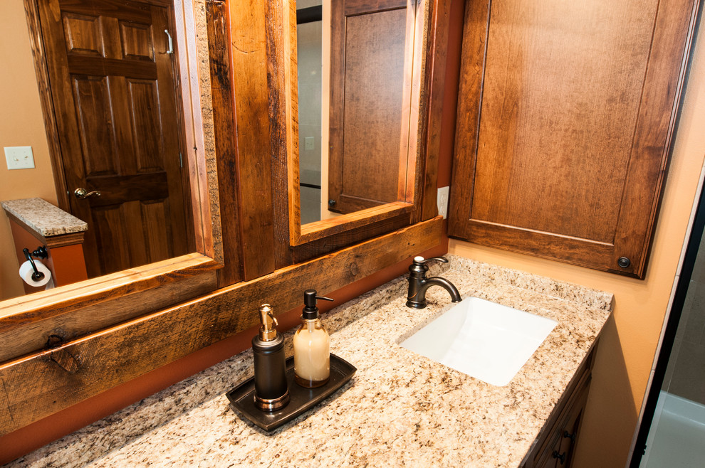 Small country master bathroom in Milwaukee with an undermount sink, shaker cabinets, medium wood cabinets, granite benchtops, an alcove shower, a one-piece toilet, beige tile, ceramic tile, orange walls and porcelain floors.