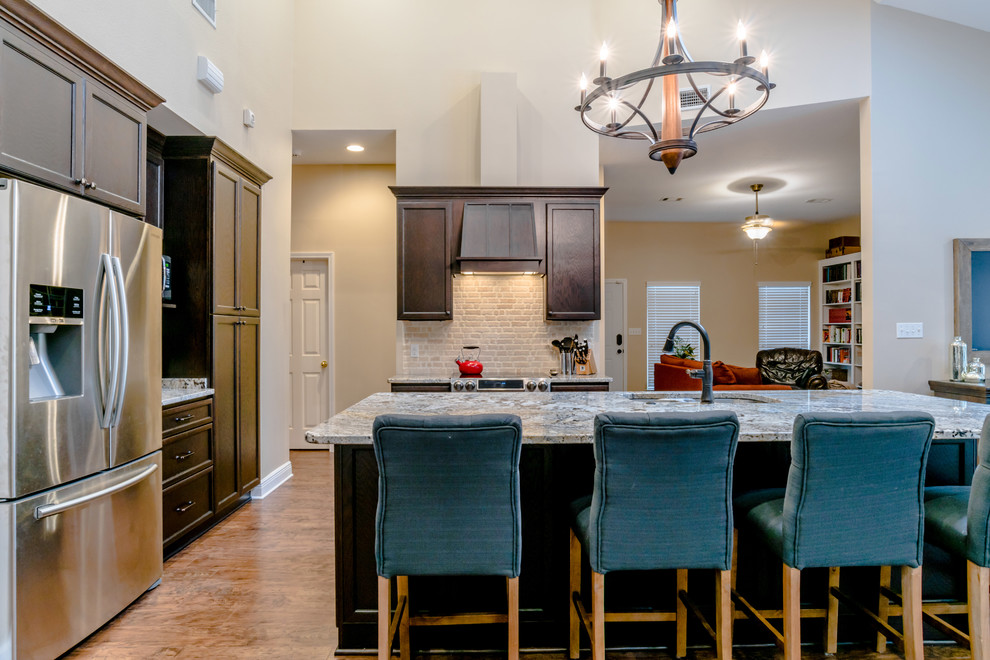 Large transitional l-shaped vinyl floor eat-in kitchen photo in Miami with an undermount sink, shaker cabinets, dark wood cabinets, granite countertops, beige backsplash, porcelain backsplash, stainless steel appliances and an island