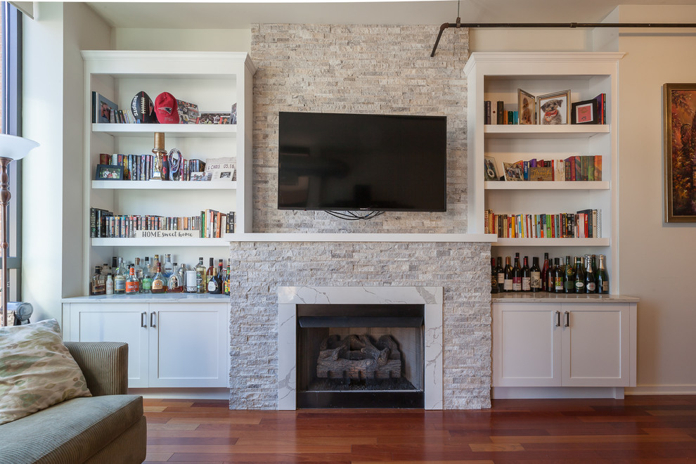 Photo of a large transitional loft-style family room in Chicago with white walls, medium hardwood floors, a standard fireplace, a stone fireplace surround, a wall-mounted tv and red floor.