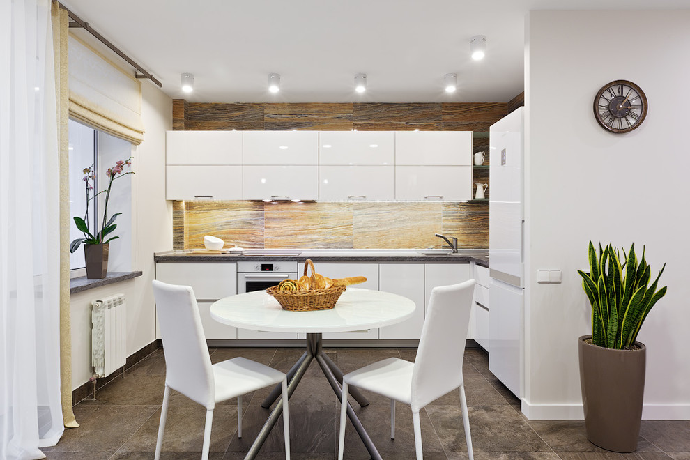 Inspiration for a contemporary open plan kitchen in Other with a single-bowl sink, flat-panel cabinets, white cabinets, laminate benchtops, orange splashback, porcelain splashback, white appliances, porcelain floors, brown floor and brown benchtop.