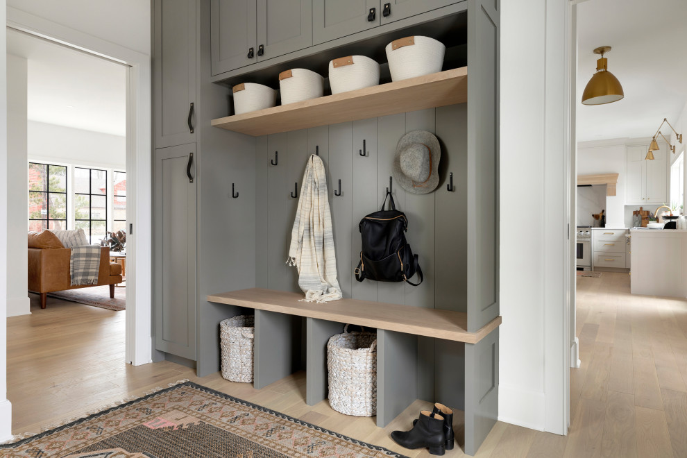 Inspiration for a transitional mudroom in Minneapolis with white walls, light hardwood floors and beige floor.