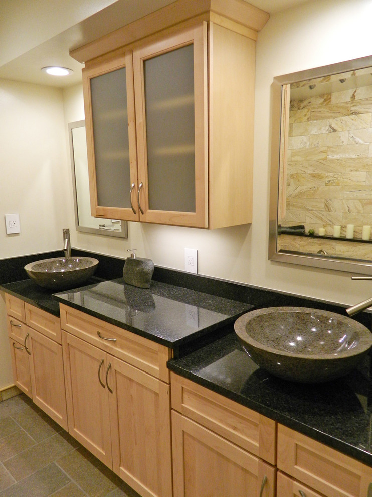 This is an example of a large asian master bathroom in Albuquerque with a vessel sink, light wood cabinets, granite benchtops, a freestanding tub, an open shower, black tile, stone tile, beige walls and porcelain floors.