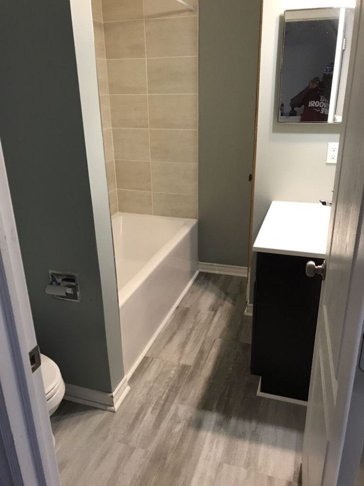 Example of a small transitional kids' beige tile and ceramic tile laminate floor, multicolored floor and single-sink drop-in bathtub design in Ottawa with furniture-like cabinets, brown cabinets, white walls, an undermount sink, solid surface countertops, white countertops, a niche and a built-in vanity