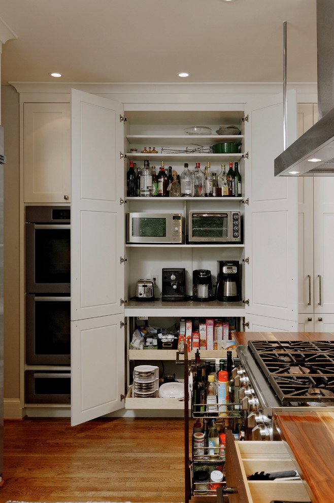 Inspiration for a mid-sized transitional u-shaped eat-in kitchen in DC Metro with an undermount sink, shaker cabinets, dark wood cabinets, multi-coloured splashback, glass tile splashback, stainless steel appliances, light hardwood floors, with island and wood benchtops.