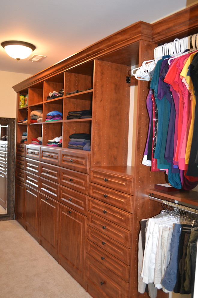 Large traditional gender-neutral walk-in wardrobe in Indianapolis with raised-panel cabinets and medium wood cabinets.