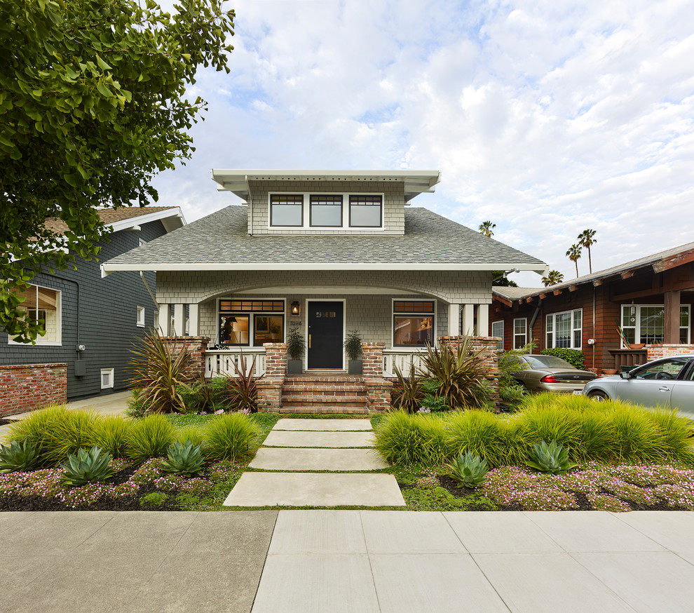 Photo of an arts and crafts two-storey grey house exterior in San Francisco with a hip roof and a shingle roof.