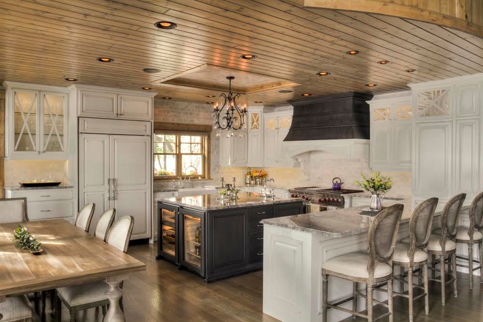 Inspiration for a mid-sized traditional u-shaped open plan kitchen in Denver with a farmhouse sink, raised-panel cabinets, white cabinets, marble benchtops, stainless steel appliances, dark hardwood floors, with island and brown floor.