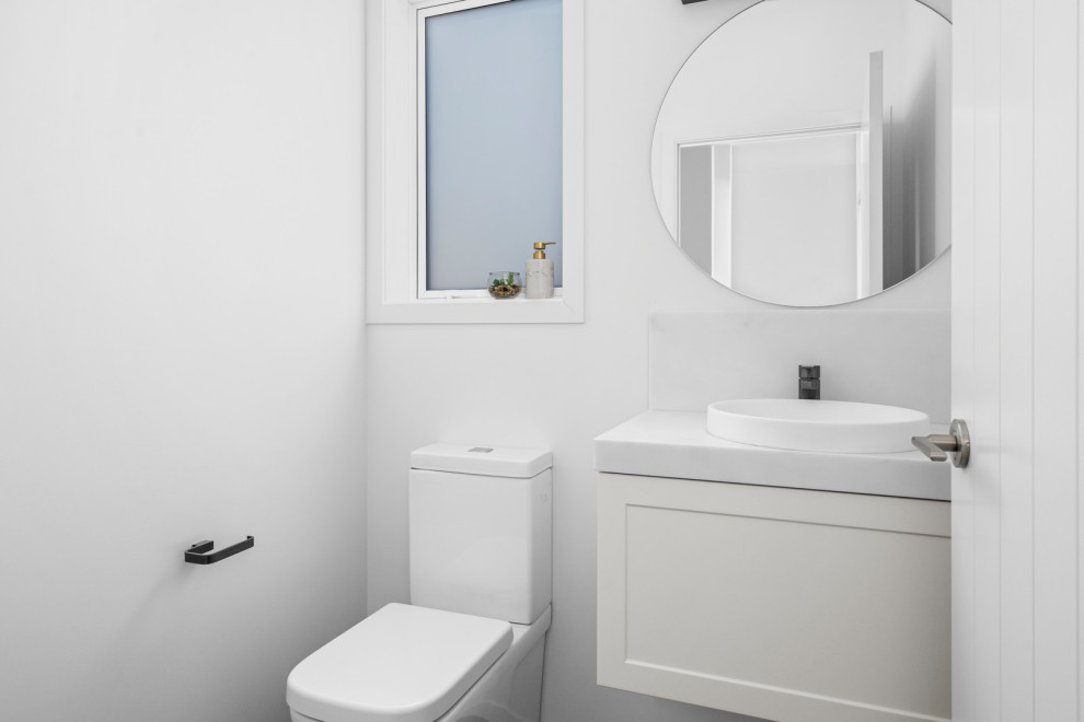 Inspiration for a small country bathroom in Wellington with white cabinets, a one-piece toilet, white walls and a floating vanity.