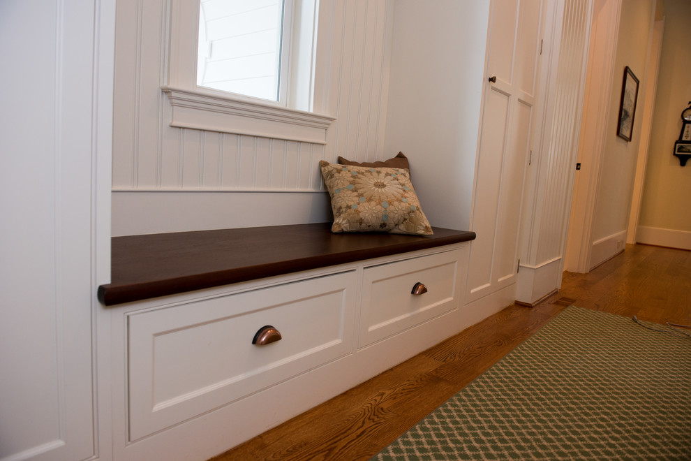 Inspiration for a transitional medium tone wood floor mudroom remodel in Charlotte with green walls