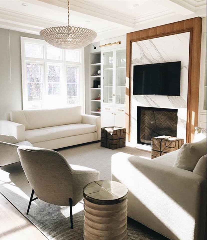 This is an example of a mid-sized traditional open concept living room in Toronto with a library, grey walls, light hardwood floors, a standard fireplace, a stone fireplace surround, a wall-mounted tv and grey floor.
