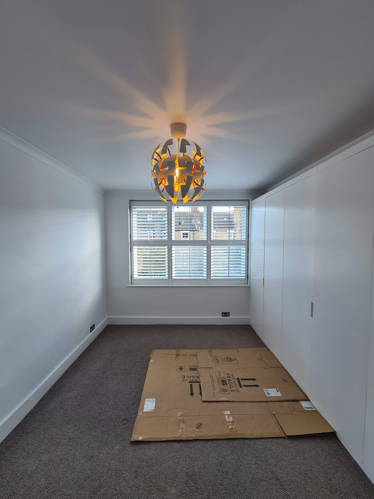 Cette image montre une chambre minimaliste de taille moyenne avec un mur blanc, un sol gris et un plafond décaissé.