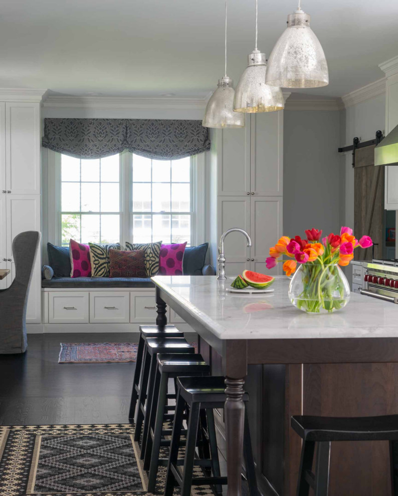 Example of a mid-sized transitional galley dark wood floor and brown floor eat-in kitchen design in Boston with white cabinets, marble countertops, white backsplash, subway tile backsplash, stainless steel appliances, an island and gray countertops