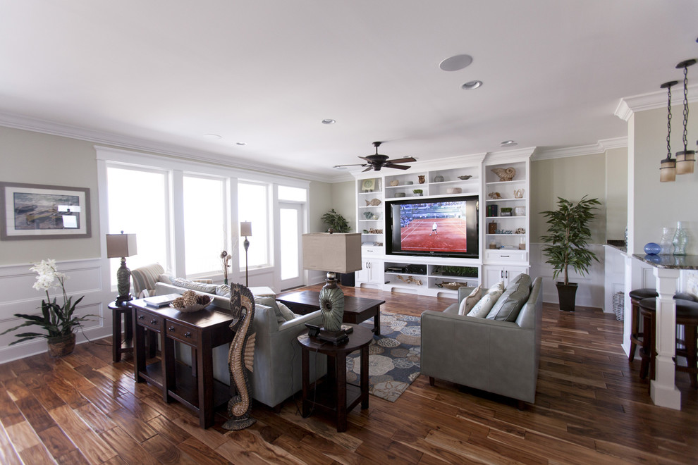 This is an example of a large beach style open concept living room in Charleston with beige walls, dark hardwood floors and a built-in media wall.