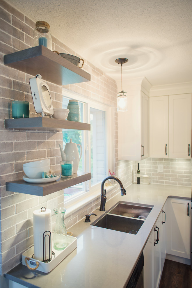 Example of a mid-sized transitional l-shaped eat-in kitchen design in Vancouver with an undermount sink, shaker cabinets, white cabinets, quartz countertops, gray backsplash, stainless steel appliances, an island, porcelain backsplash and white countertops