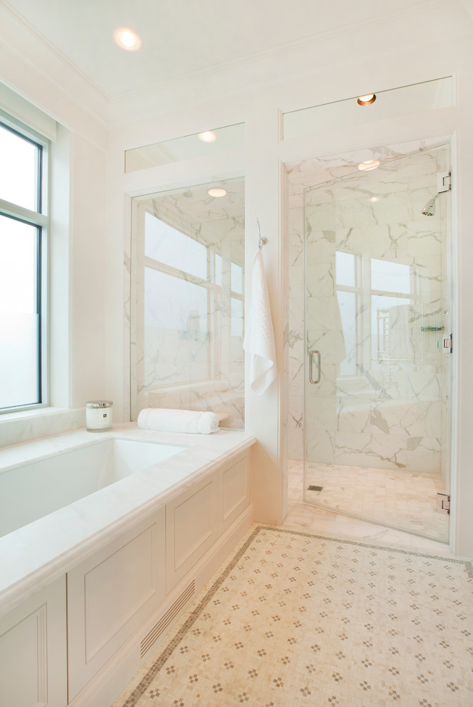 Design ideas for a large traditional master bathroom in Omaha with a pedestal sink, recessed-panel cabinets, white cabinets, engineered quartz benchtops, an undermount tub, a curbless shower, a two-piece toilet, white tile, stone tile, white walls and limestone floors.