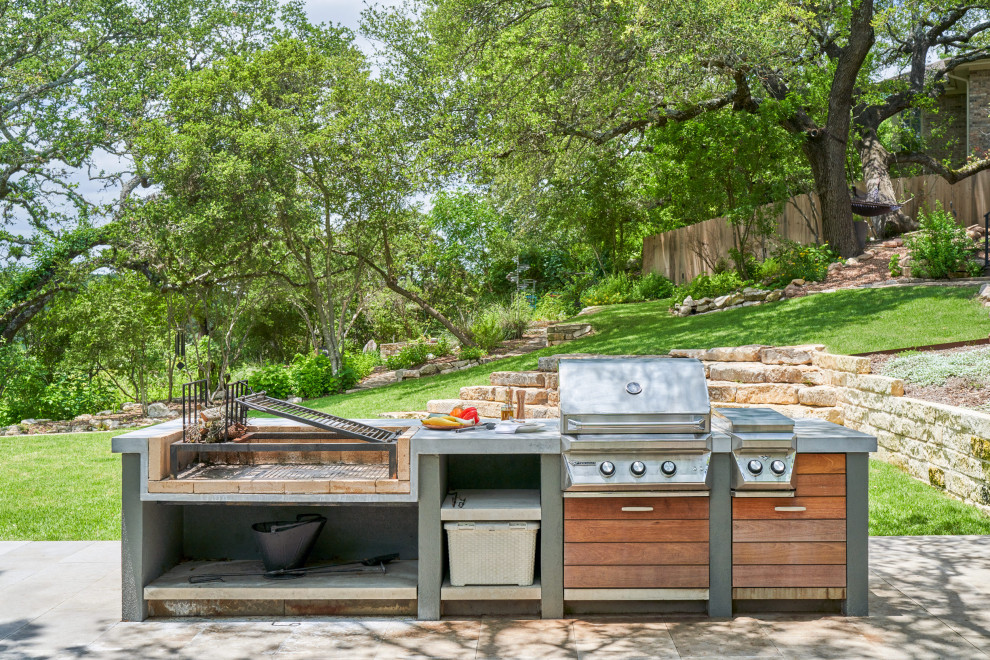 Cette photo montre une terrasse arrière tendance de taille moyenne avec une cuisine d'été, des pavés en béton et aucune couverture.